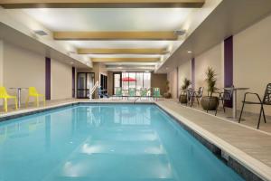 una piscina en un hotel con sillas y una mesa en Home2 Suites By Hilton Rochester Greece en Greece