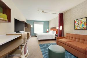Home2 Suites By Hilton Rochester Greece في غريس: غرفة في الفندق مع أريكة وسرير