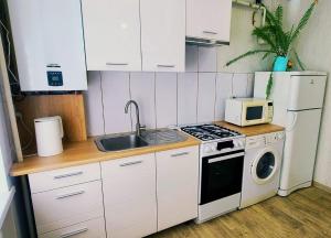 a small kitchen with a stove and a microwave at Однокомнатні Апартаменти у Співочих Фонтанів in Umanʼ