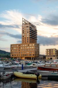 a group of boats in a marina with a tall building at Wood Hotel by Frich's in Brumunddalen