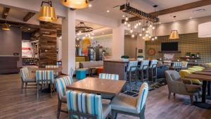 um restaurante com mesas e cadeiras e um bar em Hampton Inn Riverside Downtown em Riverside