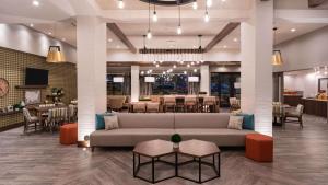 a lobby with a couch and tables and a restaurant at Hampton Inn Riverside Downtown in Riverside
