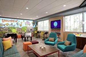 a waiting room with colorful chairs and tables and a tv at Tru By Hilton Longview in Longview