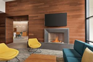 sala de estar con chimenea y TV en la pared en Homewood Suites By Hilton Wilmington Downtown, en Wilmington