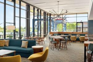 a lobby with a blue couch and tables and chairs at Homewood Suites By Hilton Wilmington Downtown in Wilmington
