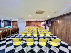 einen Konferenzraum mit gelben Stühlen auf einem karierten Boden in der Unterkunft Hotel Annakhil in Nador