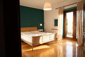 1 dormitorio con cama y pared verde en Škerlj Wine Estate, en Tomaj