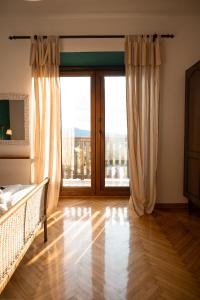 Škerlj Wine Estate في Tomaj: غرفة نوم بسرير وباب زجاجي منزلق كبير