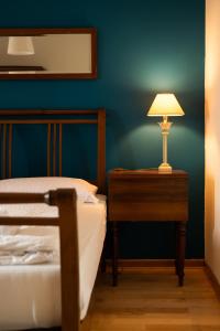 - une chambre avec un lit et une table avec une lampe dans l'établissement Škerlj Wine Estate, à Tomaj
