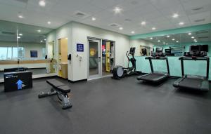 a gym with several treadmills and elliptical machines at Tru By Hilton Mobile in Mobile