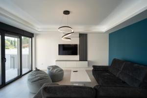 uma sala de estar com um sofá e uma televisão em Villa Zulfikar em Mostar