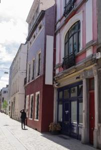 Wok Rooms في بروكسل: رجل يمشي في شارع مجاور للمباني