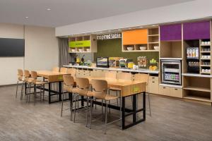 uma cafetaria com mesas e cadeiras numa loja em Home2 Suites By Hilton St. Augustine I-95 em St. Augustine