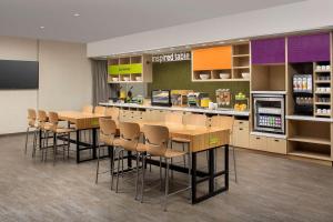 圣奥古斯丁Home2 Suites By Hilton St. Augustine I-95的一间商店里带桌椅的自助餐厅