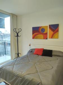 1 cama en un dormitorio con pinturas en la pared en Departamento equipado Frente al Sanatorio de la Mujer en Rosario