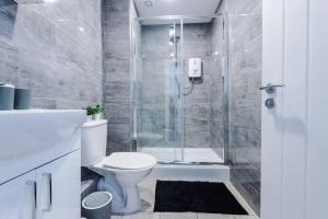 a bathroom with a shower and a toilet and a sink at Beautiful apartment tres - free public parking in Litherland +14 photos