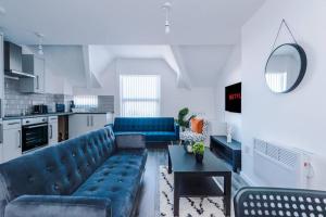 uma sala de estar com um sofá azul e uma mesa em Beautiful apartment una em Litherland