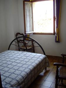 um quarto com uma cama, uma janela e uma cadeira em Maison Vacances Mer em Bages