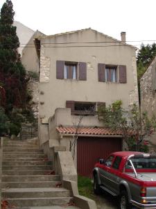 um camião vermelho estacionado em frente a uma casa em Maison Vacances Mer em Bages