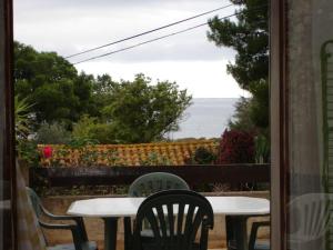 a table and chairs on a patio with a view of the ocean at Maison Vacances Mer in Bages