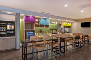 a restaurant with a table and chairs and a bar at Home2 Suites By Hilton Charlotte Northlake in Charlotte