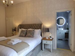 1 dormitorio con cama con espejo y lavamanos en Historic City Centre Town House, en Chester