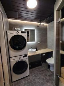 ein Badezimmer mit einer Waschmaschine und einem Waschbecken in der Unterkunft Pikkuhukka in Syöte