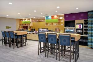 Home2 Suites By Hilton Taylor Detroit في تايلور: مطعم فيه طاولات وكراسي في محل