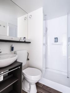 a white bathroom with a toilet and a sink at Falkensteiner Premium Mobile Homes and Camping Zadar in Zadar