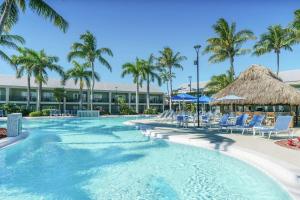 a pool at the resort with chairs and palm trees at Hampton Inn Key West FL in Key West