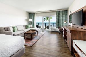 een woonkamer met een bed en een flatscreen-tv bij Hampton Inn Key West FL in Key West