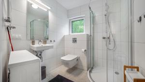 a bathroom with a shower toilet and a sink at Apartamenty Sun & Snow Zaciszna in Niechorze