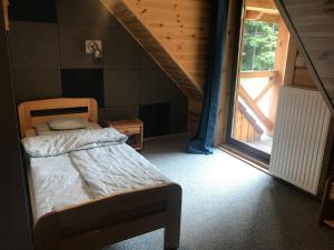 1 dormitorio con cama y ventana grande en Chata Przystanek Izery, en Szklarska Poręba