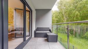 a screened in porch with a chair on a patio at Zaciszna, Sun & Snow in Niechorze