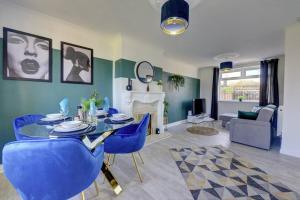 uma sala de estar com uma mesa e cadeiras azuis em Sleek and Stylish 3 Bed House In Central Hull em Hull