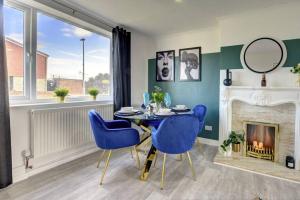uma sala de jantar com uma mesa e cadeiras e uma lareira em Sleek and Stylish 3 Bed House In Central Hull em Hull