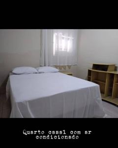 a bedroom with a white bed with a white sheet at Veraneio Dona Rosa in Piranhas