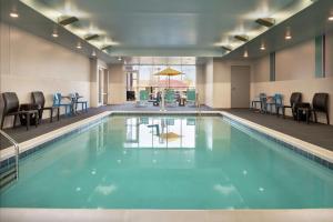 比弗克里克的住宿－Home2 Suites By Hilton Dayton/Beavercreek, Oh，大楼内一个带桌椅的游泳池