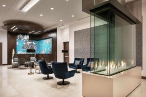 丹佛Tru By Hilton Denver Downtown Convention Center的配有椅子和大屏幕的候诊室