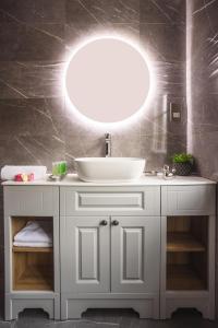 a bathroom with a white sink and a mirror at Historic City Centre Town House in Chester
