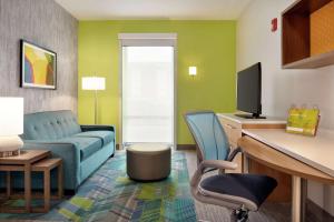 a living room with a blue couch and a tv at Home2 Suites By Hilton Dayton/Beavercreek, Oh in Beavercreek