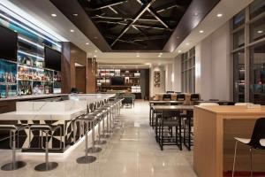 un restaurante con mesas y sillas y un bar en Tru By Hilton Denver Downtown Convention Center, en Denver