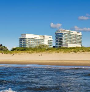 uma praia com dois edifícios altos ao fundo em Hilton Swinoujscie Resort And Spa em Świnoujście