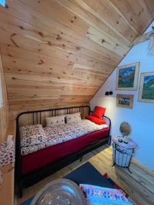 Cama en habitación con techo de madera en NV Mountain House en Žabljak