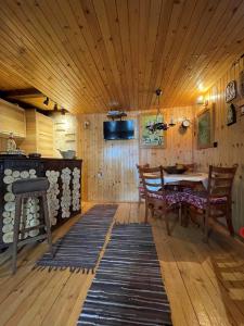a dining room with a table and wooden walls at NV Mountain House in Žabljak