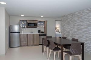 奥马哈Home2 Suites By Hilton Omaha Un Medical Ctr Area的配有桌子和冰箱的厨房和餐厅