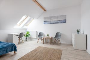 Dieses weiße Zimmer verfügt über ein Bett, einen Schreibtisch und Stühle. in der Unterkunft Quadra Rooms by 3City Rentals in Gdynia