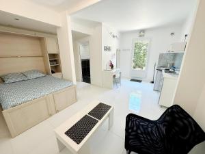 a bedroom with a bed and a table and a kitchen at Nice House Rent in Saint-Laurent-du-Var