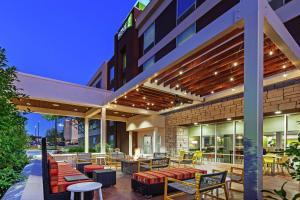 an outdoor patio of a hotel with tables and chairs at Home2 Suites By Hilton Abilene, TX in Abilene