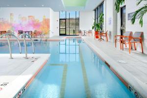 a swimming pool with tables and chairs in a building at Hilton Garden Inn Knoxville Papermill Drive, Tn in Knoxville